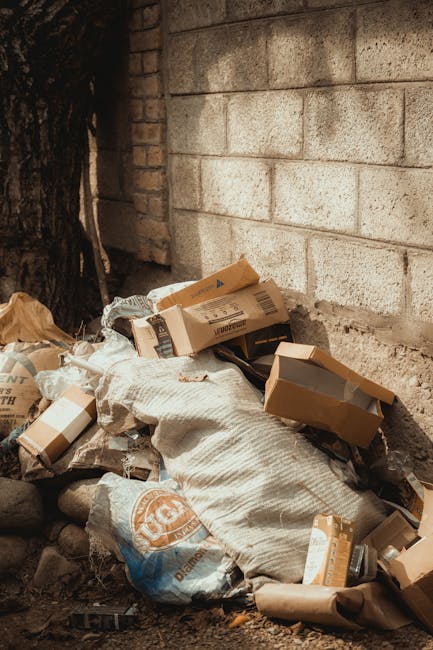 A close-up image showing several large black bin bags made of thick, glossy plastic material, filled with unidentified rubbish and tightly knotted at the tops. The bags are placed next to each other o